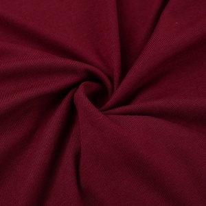 Close-up of burgundy ruffles and knitted fabric texture with soft draped folds