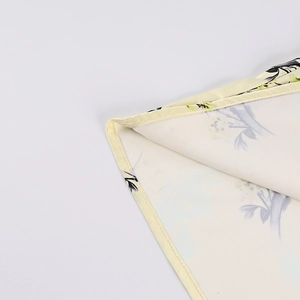 Détail de la couture fine et du motif floral sur l'ourlet de la robe en mousseline