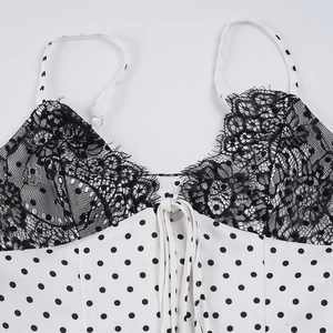 Close-up of white satin polka dot camisole with black lace trim and delicate bow detail