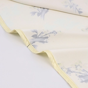 Détail de tissu à imprimé floral avec bordure en soie jaune et couture précise de robe