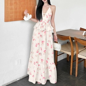 Detail view of floral halter dress featuring ruffled waist and layered cake skirt texture