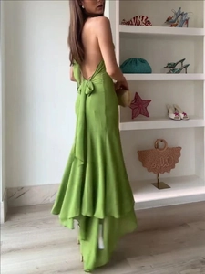 Green halter backless dress with elegant bow tie and ruffled hem in a stylish design