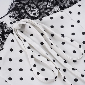 Detail of white satin polka dot camisole with black eyelash lace trim and self-tie