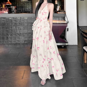 Detail of floral backless dress with ruffle waist and elegant tiered skirt overlay
