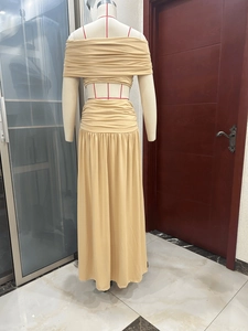 Back view of a beige two-piece set featuring a cropped off-shoulder top and maxi skirt