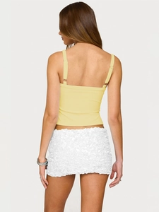 Detail view of the back of a slim fit light yellow camisole and white sequin mini skirt