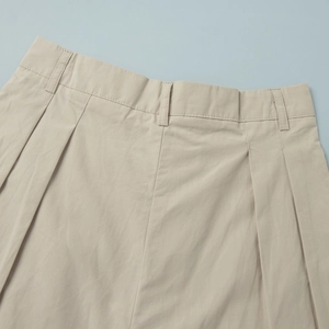 Detail view of khaki cotton shorts waist featuring belt loops and pleated design