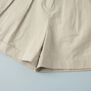 Detailed close-up of folded hem and stitching on khaki cotton casual shorts