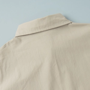 Close-up of the crisp collar and neat stitching on a beige cotton leisure shirt