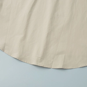 Detail of curved hemline on cotton shirt featuring clean double-needle stitching