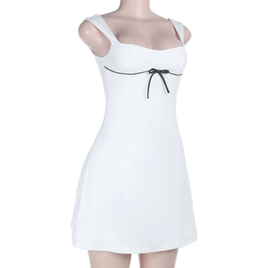 Detalle de vestido mini blanco con lazo negro y líneas de contraste elegantes