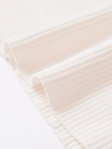 Close-up of white ribbed knit fabric texture showing soft elastic material details