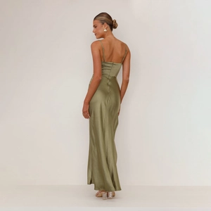 Detail of the olive green satin slip dress with a sleek back view and silky texture