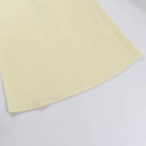 Gros plan sur les coutures et les détails de l'ourlet d'une robe crème à volants