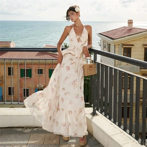 Detail of white floral halter maxi dress with deep V-neck and ruffled waist decoration