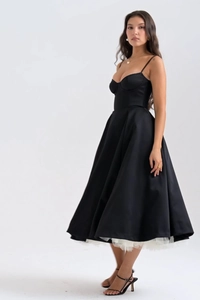 Dettaglio dell'abito nero a corsetto con gonna a trapezio e fodera in tulle