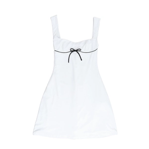 Detalle de vestido corto blanco tipo evasé con un delicato lazo negro en el escote cuadrado