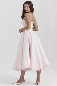Dettaglio di abito in raso rosa con spalline sottili e gonna midi svasata elegante