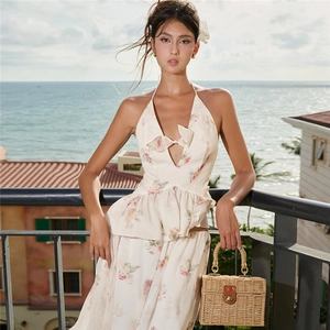 Detail of floral halter top with bow and matching skirt against a sunny seaside background