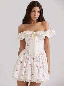 Detailansicht der cremefarbenen Satinschleife und Spitzenborte am floralen A-Linien-Kleid