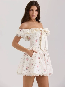 Detailansicht eines floralen Kleides mit Off-Shoulder-Ausschnitt und Satin-Schleife