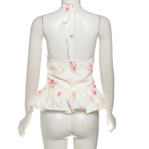 Detailed back view of a white halter neck dress with pink floral print and ruffled hem
