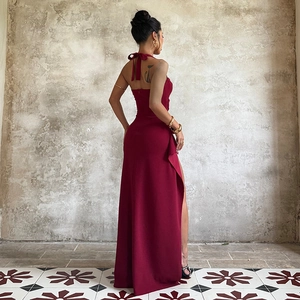 Detail of burgundy backless halter dress with bow tie and side slit for formal wear