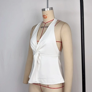 Dettaglio di un top bianco a lupetto con nodo intrecciato e scollo a V da donna