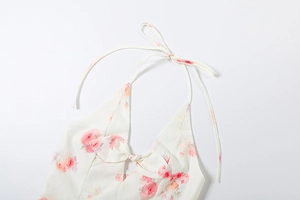 Close-up of rose print halter dress with front cut-out and bow tie decoration
