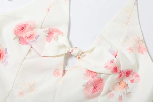 Detailed view of the V-neckline with a bow accent and pink rose floral print
