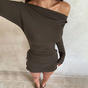 Detailed macro view of olive green knitted fabric and adjustable side drawstring on dress