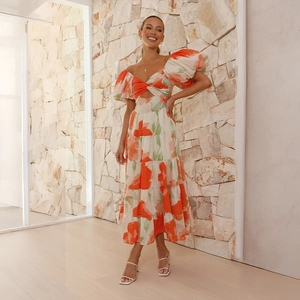 Detail of floral puff sleeve dress showing vibrant orange flower print and cut-out knot