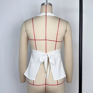 Dettaglio posteriore del top bianco a lupetto con ampio scollo e fiocco elegante in vita