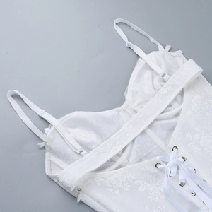 Detail view of white lace corset top featuring floral patterns and lace-up back design