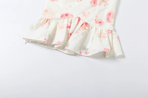 Detailed macro view of ivory ruffle hem featuring pink and orange floral print patterns