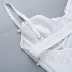 Close-up of white floral lace top featuring adjustable straps and hidden side zipper
