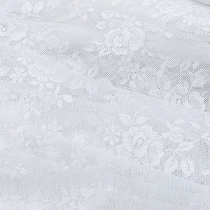 Close-up of white floral lace fabric featuring intricate rose patterns and mesh texture