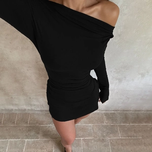 Detail of elegant black off-shoulder long sleeve mini dress with a slim fit silhouette