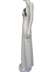 Detail of white polka dot dress featuring black lace trim and delicate spaghetti straps