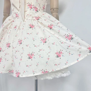 Detail eines geblümten Minikleides mit feinem Spitzenbesatz und gesmokter Taille