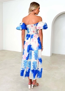 Detail view of the smocked back design and tiered floral skirt on a midi dress