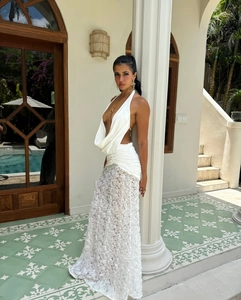 Detail of elegant white backless dress featuring 3D floral lace hem and draped neckline