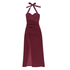 Detail of burgundy halter neck dress with bow tie and ruched high slit design