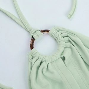 Detail of light green ribbed camisole featuring an amber resin ring on halter neckline