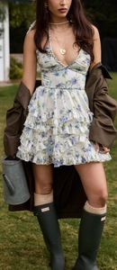 Dettaglio mini abito floreale con schiena scoperta, balze a strati e scollo all'americana