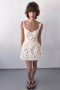 Dettaglio mini abito bianco a fiori rossi con scollo a cuore e spalline sottili