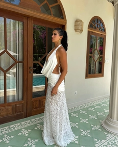 Detail of white halter neck dress featuring 3D rose lace texture and backless cut