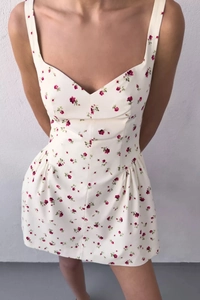 Dettaglio dell'abito corto floreale con motivi a fiori rossi e vita arricciata elastica