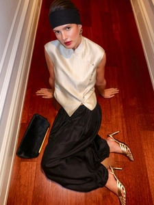 Detail of champagne satin sleeveless top featuring a mandarin collar and side knots