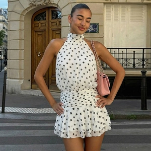 Detail of polka dot halter dress featuring tiered ruffle hem and slim waist design